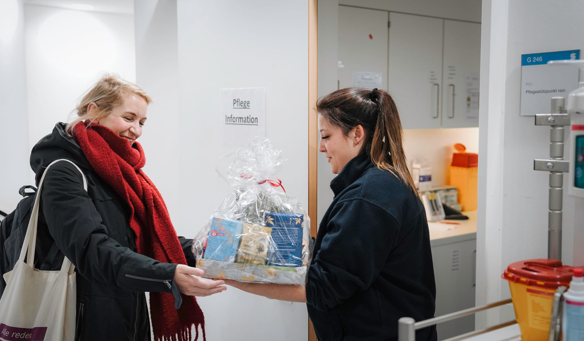 Ines Schwerdtner überreicht einer Pflegerin einen kleinen Korb mit Geschenken.